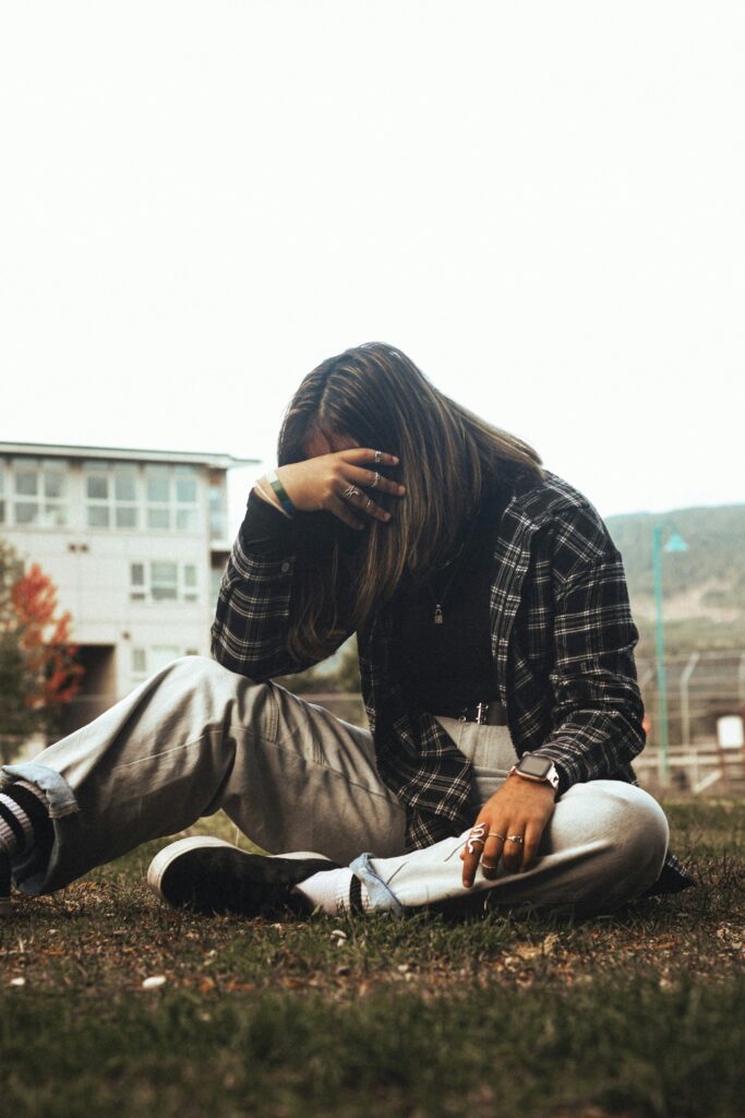 Person curled up with eyes closed, surrounded by soft textures, symbolizing internal overwhelm and emotional flashback response.